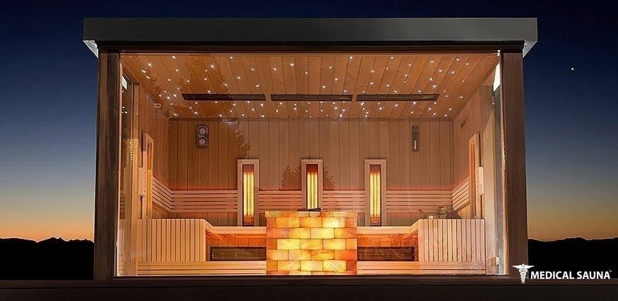 Large outdoor wooden sauna with curved roof, glass door, and seating for 10 people, surrounded by trees